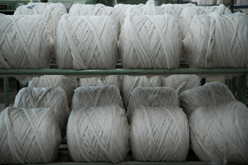 Bundles of white yarn on a metal rack
